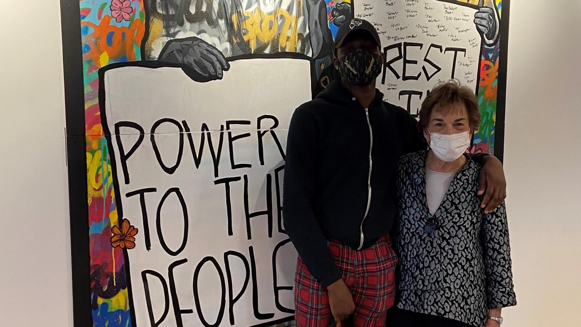 Schakowsky and Navigator stand in front of artwork